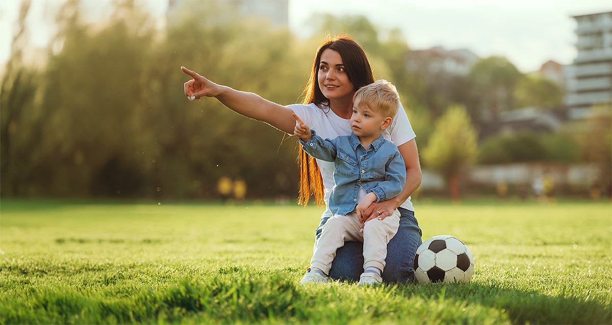Kleiner Junge mit Mutter im Gruenen ohne Brille